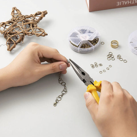 Person using pliers with Over 1000 Open Jump Rings Kit With 40Pcs 12Mm Lobster Clasps And Jump Ring Opener for jewelry making.