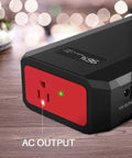 Close-up of Massive 24000mAh Portable Power Bank with 110V 65W AC outlet, showing AC output and USB port on a wooden surface.