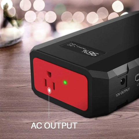 Close-up of Massive 24000mAh Portable Power Bank with 110V 65W AC outlet, showing AC output and USB port on a wooden surface.