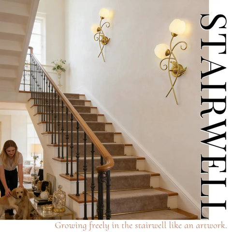 Gold wall sconces set of two illuminate a stairwell with a modern black and brass design, featuring thick clear glass shades.