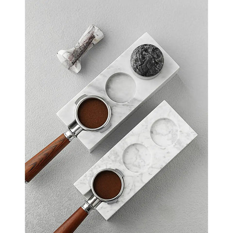 Top Shelf Marble Espresso Tamper Holder Stand Fits 51mm And 54mm Coffee Tools with espresso grounds on a marble base.