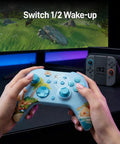 Hands holding Grab This Limited Edition Starsand Island Collab Wireless Pc Controller Featuring Blazing Fast Three Point Two Five Millisecond Latency Tmr Joysticks For Pro Level Esports Gaming With Cool Light Blue Gradient Shell And Adorable Capybara Artwork in front of gaming screen.