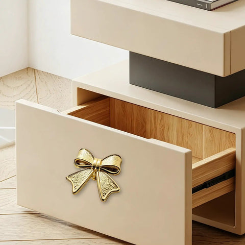 Six Piece Zinc Alloy Bow Drawer Knobs With Vintage Plating And Smooth Curved Handles For Dressers And Vanity Furniture Upgrades. Bow knob on beige drawer.