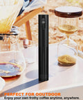 Soenglyun 3 Speed Rechargeable Milk Frother Handheld Press With Travel Cover Quiet Foam Maker For Latte Cappuccino Coffee Shop Quality Drink At Home Fast And Easy Use Cordless Battery Operated in black, placed on a table outdoors with coffee equipment.