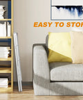 Three Step Aluminum Folding Ladder With Wide Anti Slip Pedals, 330 Lb Capacity, folded beside a sofa in a living room
