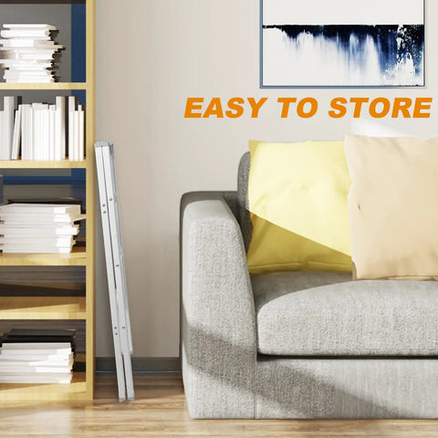 Three Step Aluminum Folding Ladder With Wide Anti Slip Pedals, 330 Lb Capacity, folded beside a sofa in a living room