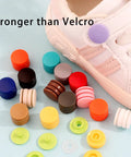 Assorted T5 plastic snap buttons in 14 colors next to a shoe, showcasing 120 Sets T5 Plastic Snap Buttons No Sew No Tools Required Hand Press Fasteners For DIY Crafts Grab And Go Clothing Repair And Home Decor 14 Color Options Durable Eco Friendly Resin.