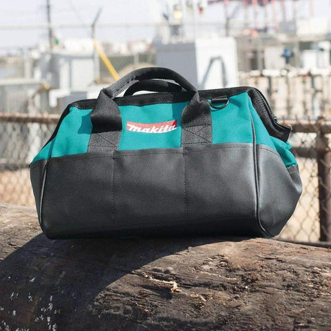 Contractor Tool Bag 14 Inch Heavy Duty With Industrial Fabric Durable Zipper Reinforced Handles And Shoulder Strap For Easy Carry On Rough Job Sites Everyday Use on a log outdoors.