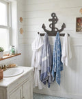 Badass Vintage Vibes 10 Inch Cast Iron Nautical Anchor Hook For Heavy Duty Wall Storage And Totally Rad Farmhouse Decor adding towels in a bathroom.