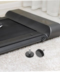 Four Piece Adjustable Treadmill Levelers With Non Slip Swivel Base And Universal Mounting Bolts against a treadmill on carpet.