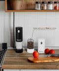 Upgraded Electric Salt And Pepper Grinder Set With Dual Charging Base, Rechargeable Operation Eliminates Frequent Battery Replacement For Eco Friendly Convenience In Your Home Kitchen Setup Today on countertop with spices and tomatoes.