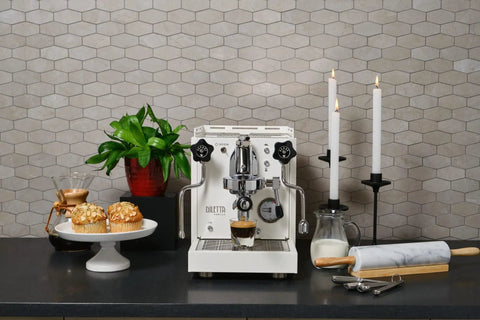 Next Level Home Bar Essentials Italian Handcrafted Espresso Machine With Heat Exchanger And E61 Manual Controls Badass Stainless Steel Chassis Three Liter Tank Fresh White Finish on kitchen countertop.