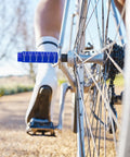Close-up of durable navy blue stunt pegs installed on BMX bike, Two Pack Aluminum Alloy Bike Pegs For Three Eighths Inch Axles Anti Skid Foot Pegs
