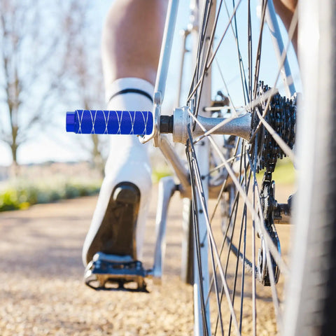 Close-up of durable navy blue stunt pegs installed on BMX bike, Two Pack Aluminum Alloy Bike Pegs For Three Eighths Inch Axles Anti Skid Foot Pegs