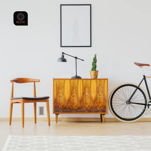 Mid-century modern living room with chair, cabinet, and bicycle against white wall.