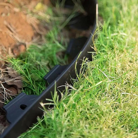 2 Inch Tall Garden Landscape Edging Kit With 20 Ft Length And 20 Spiral Spikes Black Plastic Border installed between grass and soil