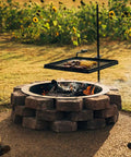 Adjustable Swivel Grill Grate For Open Fire Cooking With Spike Pole Steel Mesh Wire Grate installed over outdoor fire pit