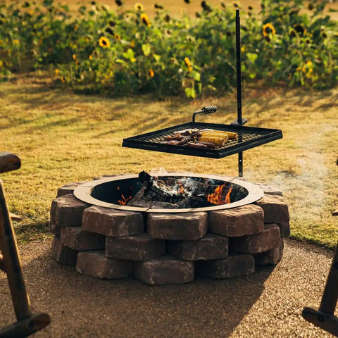 Adjustable Swivel Grill Grate For Open Fire Cooking With Spike Pole Steel Mesh Wire Grate installed over outdoor fire pit