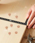 Wood board with 50 Pack DIY Wooden Hole Caps and Pocket Hole Plugs Hardwood Wood Plugs For Cabinets laid out next to a ruler.