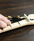 Pro Level Guitar Nut Scribe Tool And Dead On Saddle Height Marker For Acoustic Classical Repairs Durable Aluminum And Brass Build Black Grip close-up on guitar neck.