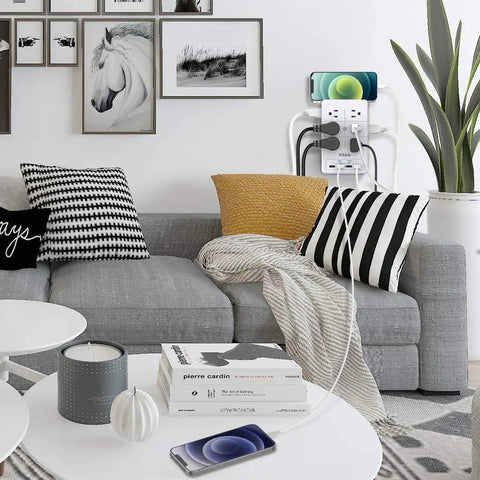 Living room with mounted 2 Pack Surge Protector Power Strip With 4 USB Ports, charging devices next to a gray couch with pillows