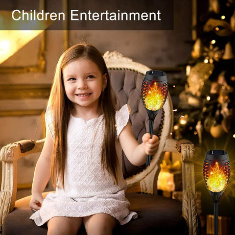 Child holding Eight Pack Solar Torch Lights Outdoor With Flickering Real Flame Effect, Waterproof Garden Path Yard Lights