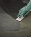 Person using Smooth Grip Sealer Applicator Brush on tile surface for grout treatments with precise drip lock.