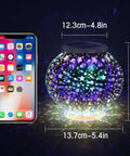 Color Changing Mosaic Solar Powered Glass Globe Light next to phone for size comparison, stars pattern, 6.7 Inch, lit up indoors.