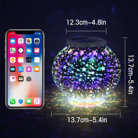 Color Changing Mosaic Solar Powered Glass Globe Light next to phone for size comparison, stars pattern, 6.7 Inch, lit up indoors.