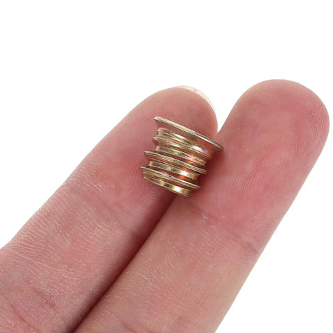 Person holding M6x10mm Countersunk Flange Wood Nut Inserts for cabinets and desks, showcasing size and detail of carbon steel fasteners.