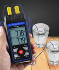 Dual Channel K And J Type Thermocouple Thermometer With Alarm And Compensation Adjustment held over glasses of water