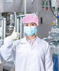 Hella Breathable Anti Static Mesh Work Cap Pink Dustproof Protective Hat Straight Up Ideal For Electronics And Cleanrooms worn by a lab worker, thumbs up.