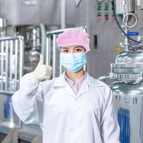 Hella Breathable Anti Static Mesh Work Cap Pink Dustproof Protective Hat Straight Up Ideal For Electronics And Cleanrooms worn by a lab worker, thumbs up.