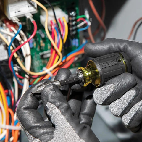 Gloved hands using Compact 3-Piece Tool Set with Mini Ratchet near electronics. Color coded and impact rated, for tight spaces.