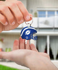 Close-up of person handing over blue helmet-shaped keychain from Helmet Shape Sublimation Keychain Blanks Kit, 20 Pieces