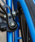 Close-up of V Brake Pads 70mm Set With Hex Nuts And Spacers For Bicycle installed on blue bike frame, rear view.