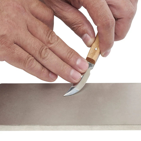 Close-up of hands sharpening knife on 8 Inch Diamond Sharpening And Flattening Stone Double Sided 180/600 Grit Bench Stone