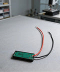 Straight Up Led Battery Voltage Gauge 5V To 21V with black and red wires on green PCB for checking lithium cells.