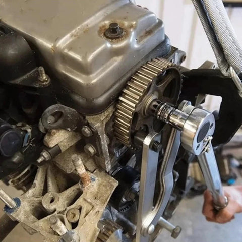 Camshaft sprocket locking tool with ergonomic handle installed on timing pulley beside the engine