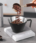 Two Pack Stainless Steel Espresso Cups With Handle, Double Spout Measuring Cup With Dual Scale, V Shaped Mouth, 3.4oz 100ml, Black Coffee Shot Cups being filled with coffee beans on a digital scale.