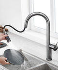 TXGJWRA Green Pull-Faucet with 360-Degree Swivel Spray Head, Single Hole Sink Mixer in use, washing a plate.