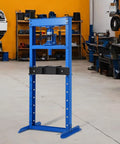 Heavy Duty 12 Ton Hydraulic Shop Press with adjustable table, blue steel frame, designed for auto repair in a garage setting.