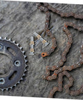 Rusted chain and sprocket with small metal parts, related to Door Hinge Repair Kit Pin And Bushing For Automotive Door Hardware