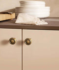 6 Pack Antique Brass Zinc Alloy Cabinet Knobs And Drawer Pulls For Kitchen Cabinets shown installed on beige doors