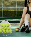 Woman on tennis court with 3 Pack Mesh Ball Bags Set Nylon Drawstring Organizer Bags 10x11.5 Inches holding tennis balls next to her