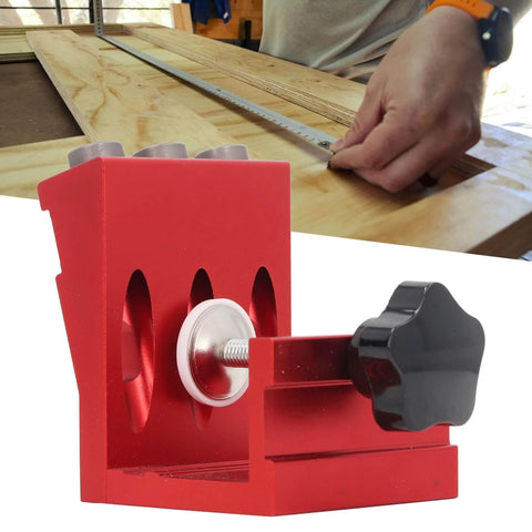 Pocket Hole Jig Set With Steel Bushings And Anodized Aluminum Body Delivers Precise 15 Degree Dowels For Woodworking, Cabinetry, And Furniture Assembly, Industrial Grade Durability, Reliable Accuracy, Ideal For Repeated Use In Shops shown in red with a woodworking setup in the background.