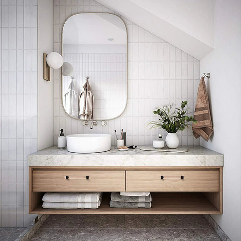 Modern bathroom vanity with white basin, marble countertop, round mirror, and wooden cabinet in a sleek design.