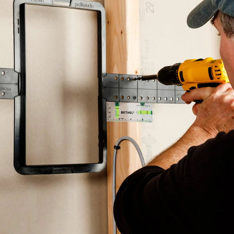 Person using a Nifty Tiny Handheld Magnetic Bubble Spirit Level With Clear Acrylic Measure Stick for wall alignment while drilling.