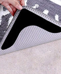 Hand lifting corner of rug to reveal Ultra Sticky Rug Grippers For Anti Curling Non Slip Rug Tape Keeps Your Rug In Place And Makes Edges And Corners Flat 8 Pack Black Strong Adhesive For Long Lasting Hold No Residue Reusable Multi Pack For High Traffic Areas.