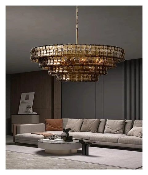 Next Level French Gray Glass Ceiling Pendant Light Sleek Round Chandelier with warm ambiance over modern living room sofa.